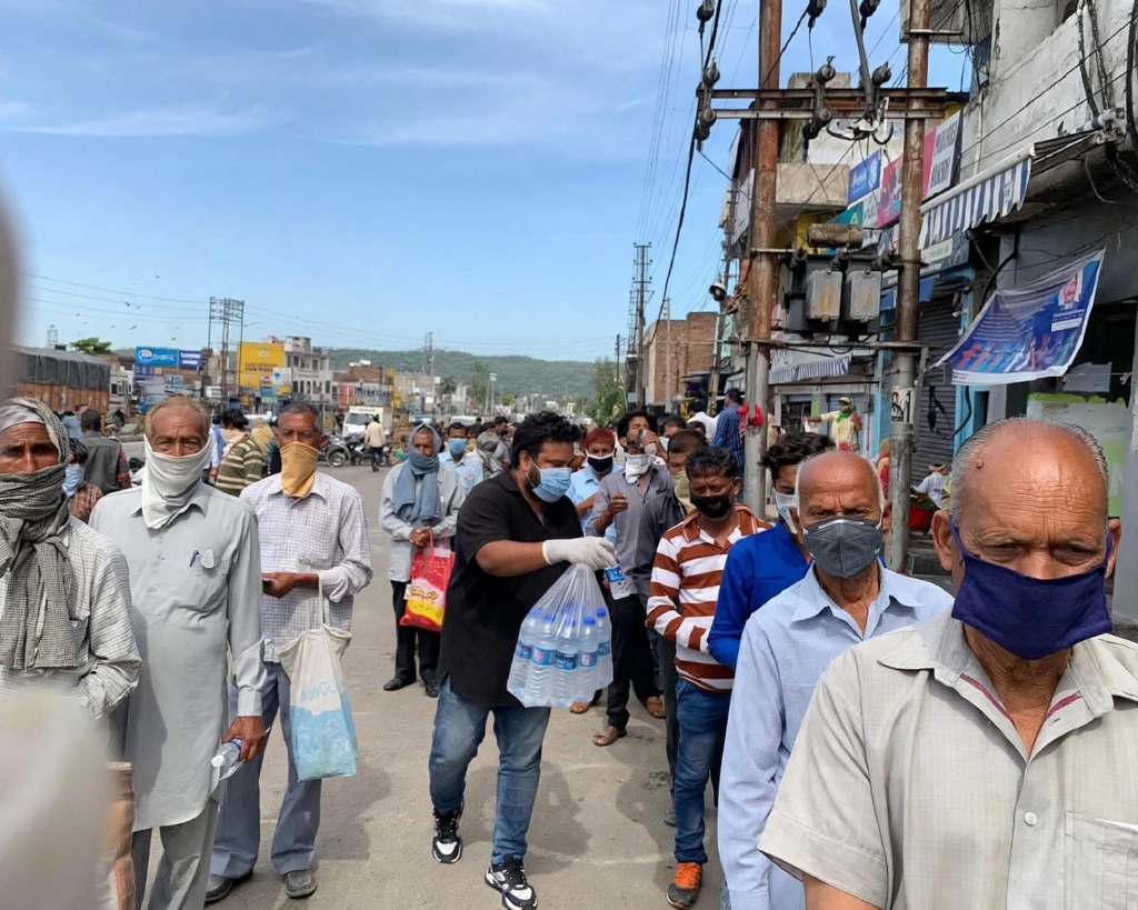 Drinking water bottles and relief aid distribution queue during heatwave